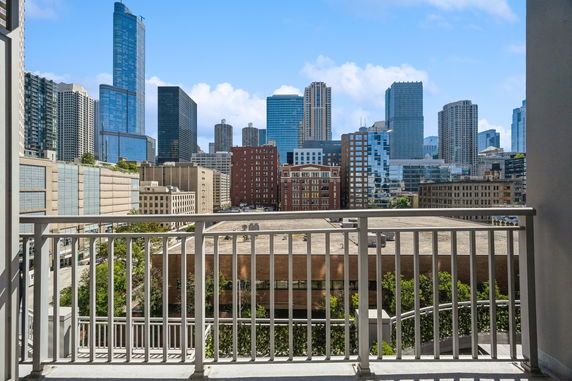 View of a skyline with multiple high-rise buildings seen from a balcony.
