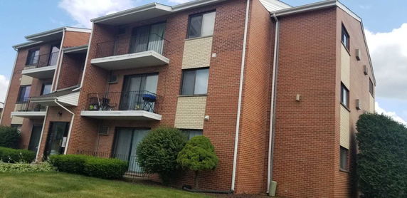 Front view of a brick apartment building with multiple balconies.