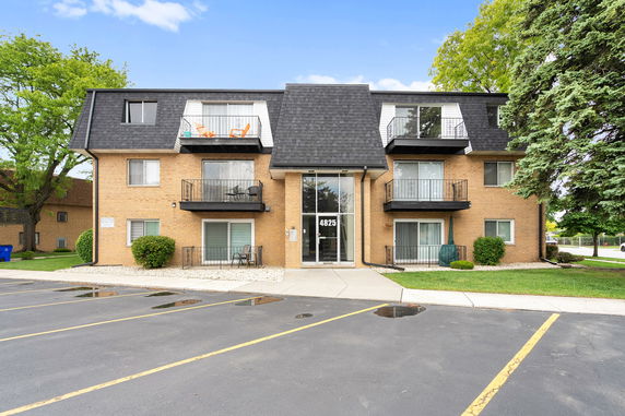 Front view of a three-story apartment building with balconies.