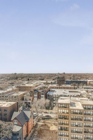 Panoramic view of a cityscape with various buildings and structures under a clear blue sky.