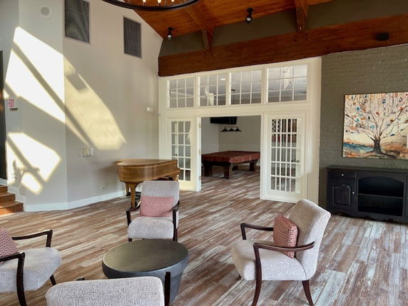 Interior view of a recreation area with seating and a pool table.