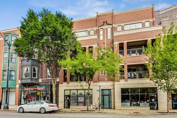 Front view of a multi-story brick building with balconies.