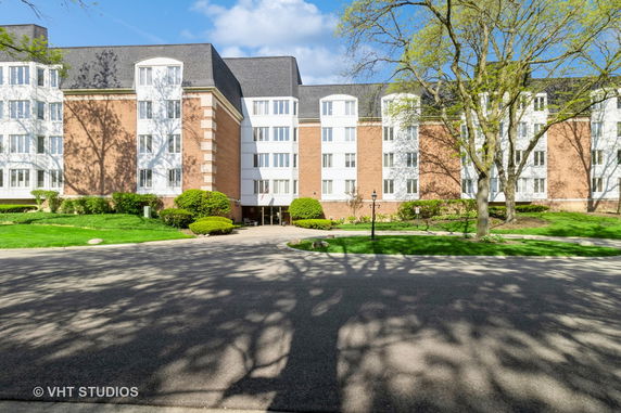Front view of a multi-story residential building with brick and white exterior.