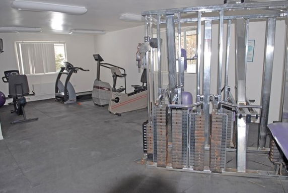 Indoor gym area with exercise equipment including a stationary bike and weight machine.