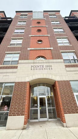 Front view of a multi-story residential building with brick facade.