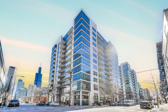 Front view of a modern multi-story building with large windows and balconies.