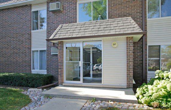 Front view of a building with a glass entrance and brick facade.