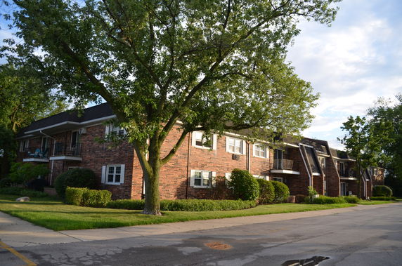 Front view of a brick apartment building with multiple balconies.