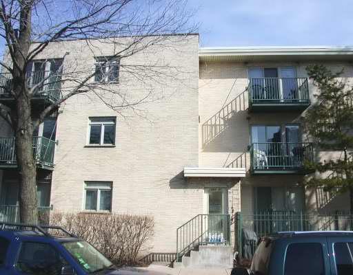 Front view of a multi-story apartment building with balconies.