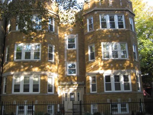 Front view of a multi-story building with large windows and a central entrance.