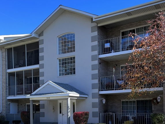 Front view of a three-story apartment building with balconies.