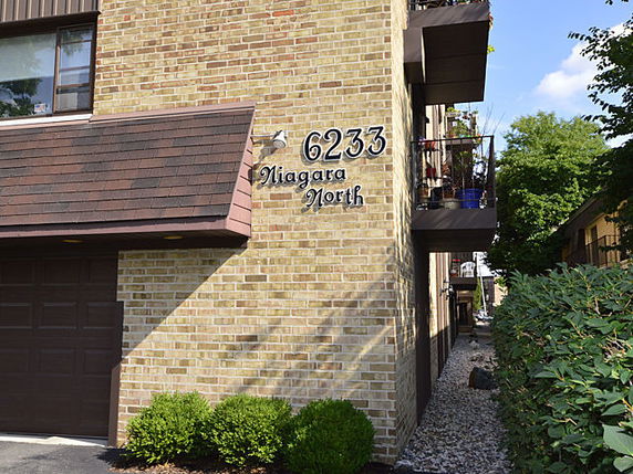 Front view of a multi-story brick building with balconies.