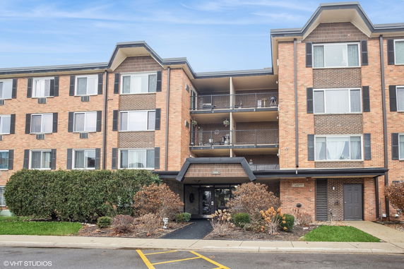 Front view of a multi-story apartment building with balconies.