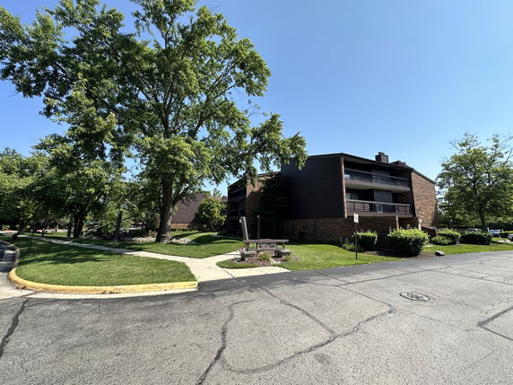 Front view of a multi-story apartment building with balconies.