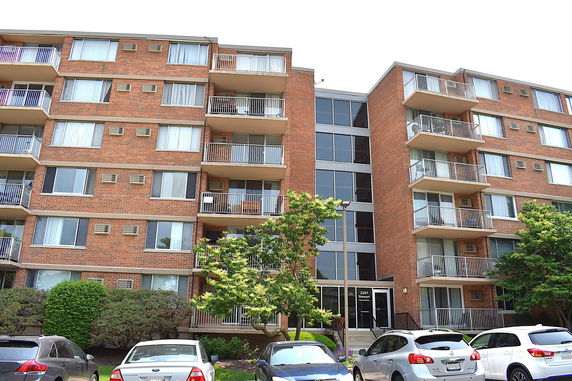 Front view of a multi-story apartment building with balconies.