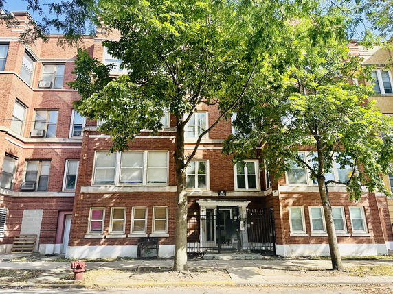 Front view of a multi-story brick apartment building.