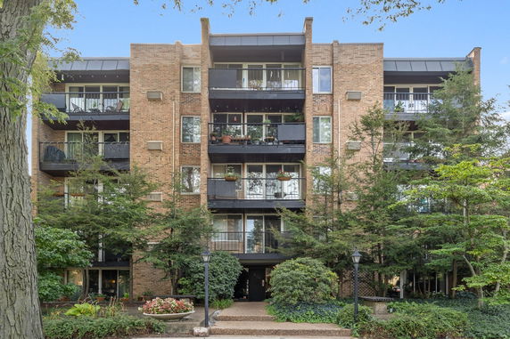 Front view of a multi-story brick residential building with balconies.