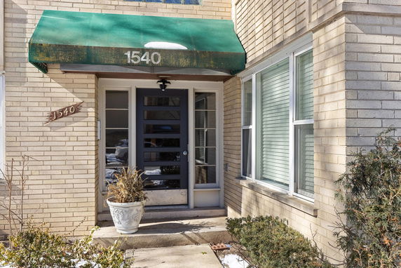 Front view of a house entrance with a green awning.