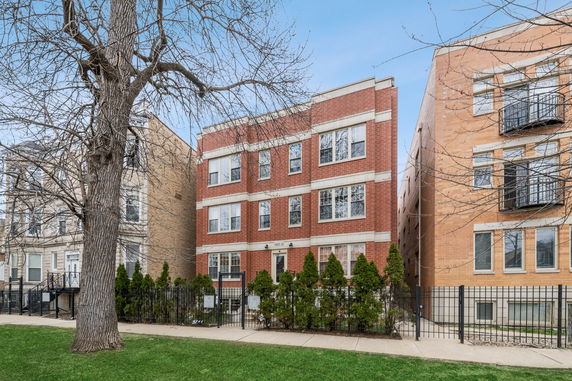 Front view of a multi-story brick apartment building.