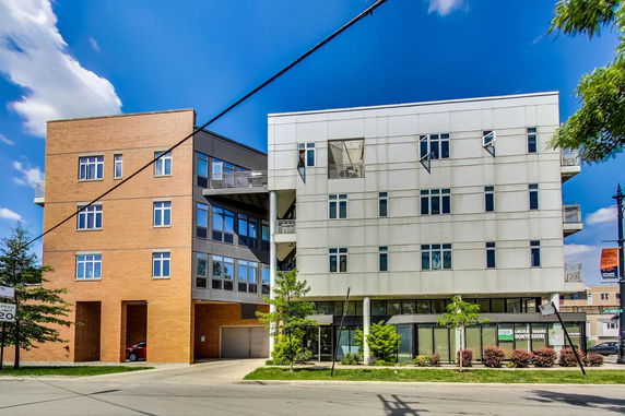 Front view of a modern multi-story building with a combination of brick and metal facade.