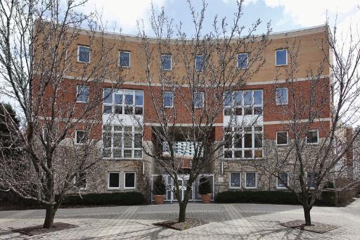 Front view of a multi-story building with a brick facade and large windows.