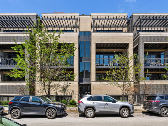 Front view of a multi-story building with balconies and modern design.