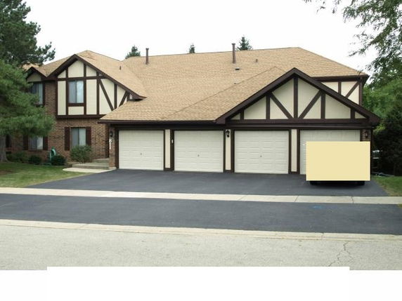 Front view of a house with Tudor-style design and a triple garage.