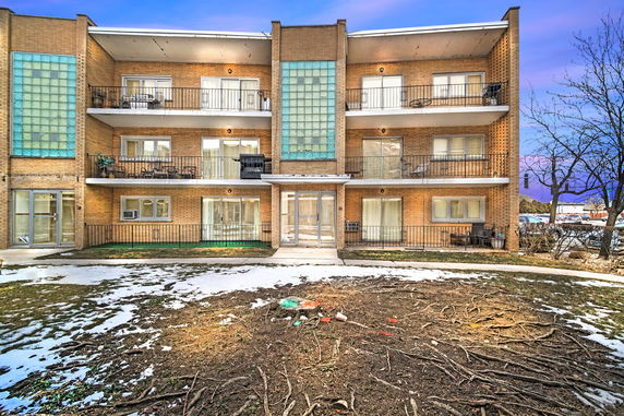 Front view of a three-story apartment building with balconies.