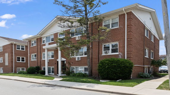 Front view of a brick apartment building with white trim.