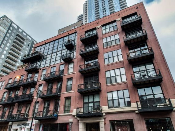 Front view of a multi-story brick building with balconies.