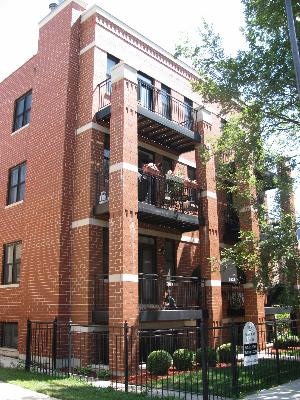 Front view of a multi-story brick building with balconies.