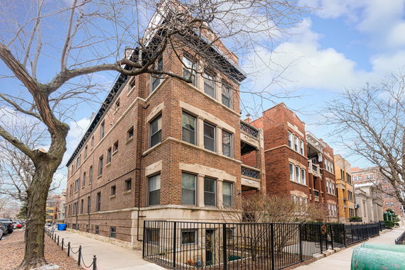 Front view of a multi-story brick building on a city street.