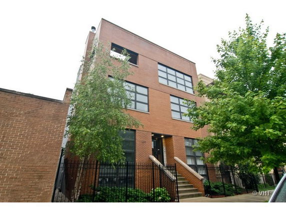 Front view of a multi-story building with brick facade and large windows.