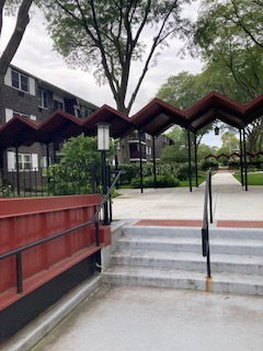 View of a building with a distinctive zigzag roof structure at the entrance.