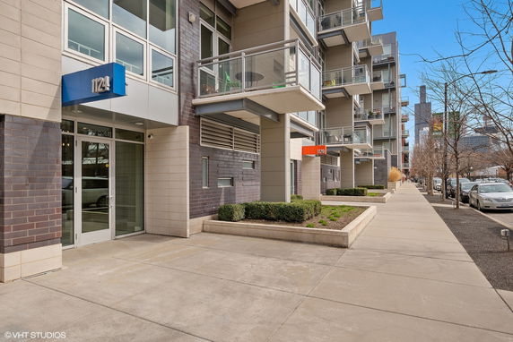 Front view of a modern multi-story apartment building with balconies.