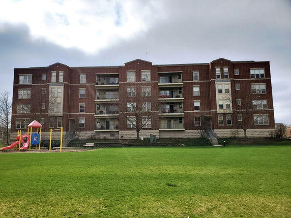 Front view of a multi-story apartment building with balconies.