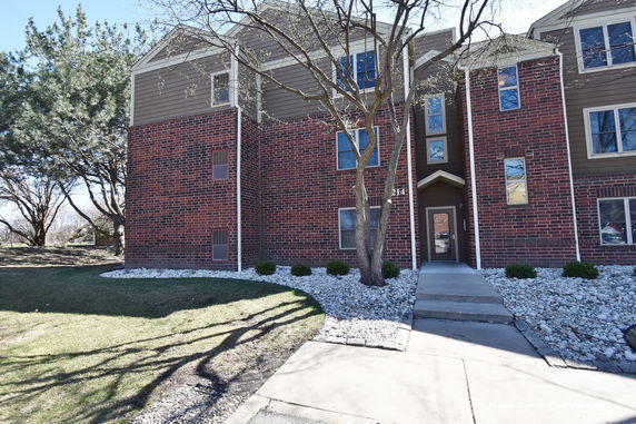 Front view of a multi-story building with brick and siding exterior.