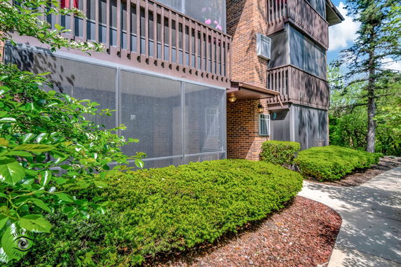 Front view of a brick apartment building with multiple balconies and air conditioning units.