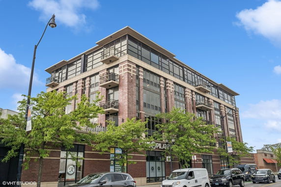 Front view of a modern multi-story building with large windows and balconies.