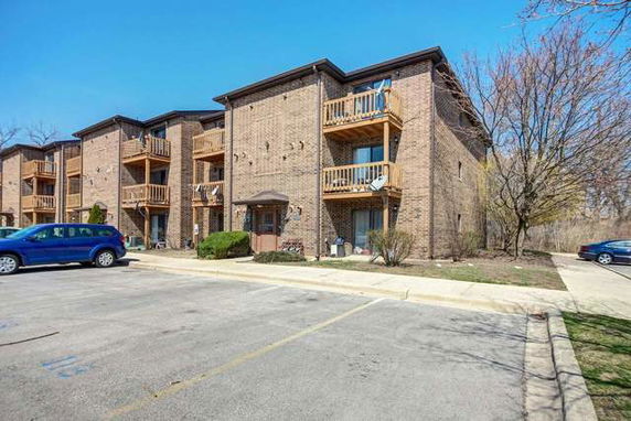 Front view of a multi-story apartment building with brick exterior and balconies.