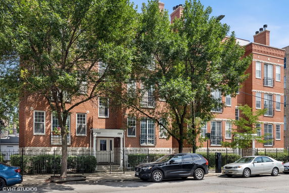 Front view of a multi-story brick building with multiple windows.