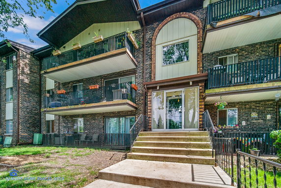 Front view of a multi-story brick building with balconies.