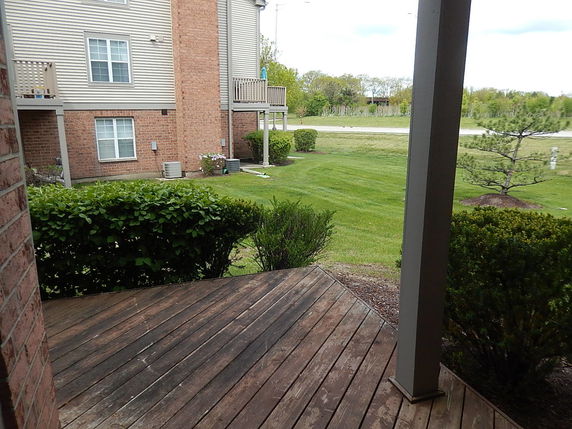 View of the surrounding area including adjacent building and grassy landscape.
