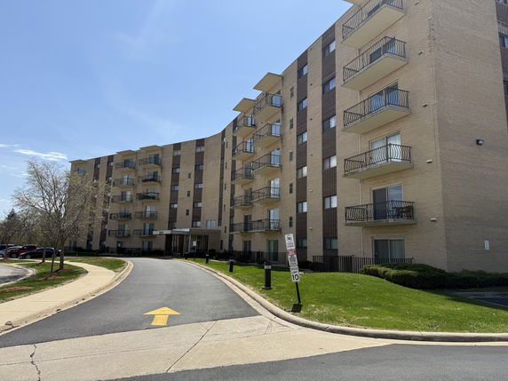 Front view of a multi-story apartment building with balconies.