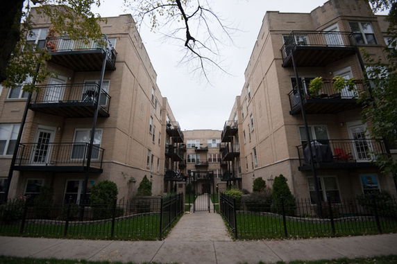 Front view of a multi-story apartment building with balconies.