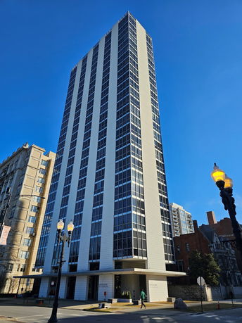 Front view of a tall modern high-rise building with a striped facade design.