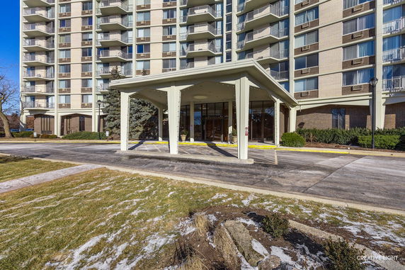 Front view of a multi-story building with a covered entrance.