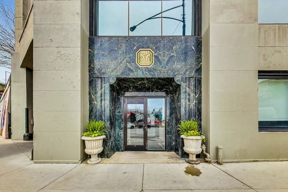 Front view of a building with a decorative entrance and large glass windows.