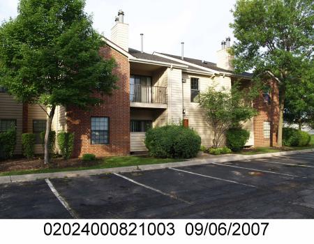 Front view of a multi-story apartment building with brick and siding exterior.