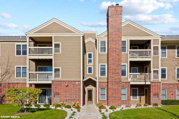 Front view of a multi-story apartment building with balconies.